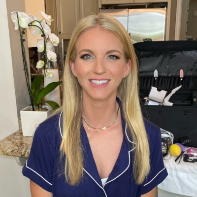 Bridesmaid with sleek straight blonde hair and natural makeup, wearing navy pajamas during bridal party preparations