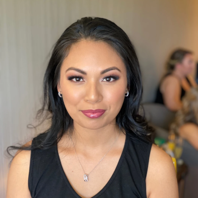 Bridesmaid with glamorous smokey eye makeup and loose waves, featuring berry lip color and elegant black hair styling