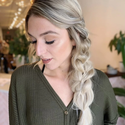 Bohemian side braid with textured platinum blonde hair, featuring loose pulled-apart styling and romantic messy finish